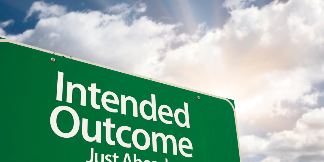 A green road sign with white text reads "Intended Outcome Just Ahead." The sign is mounted on two wooden posts and is set against a vibrant blue sky with fluffy white clouds and sun rays breaking through. In the bottom left corner, there's a logo that says "SHARITY" with the tagline "PARTNER. POWER. PROPEL." below it.